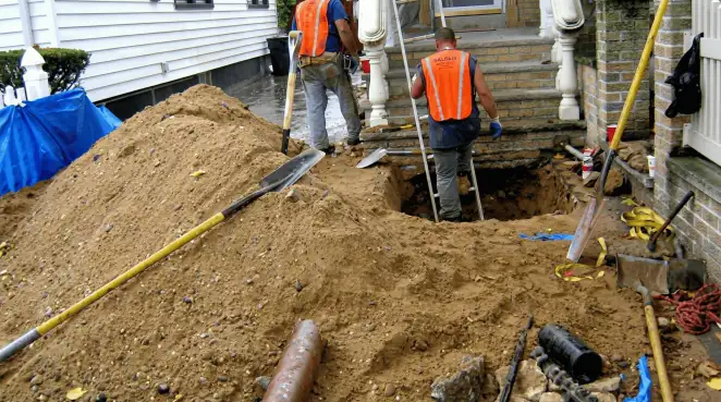 Contractors performing foundation protection and exterior drainage excavation near residential home steps in Fort Worth, TX
